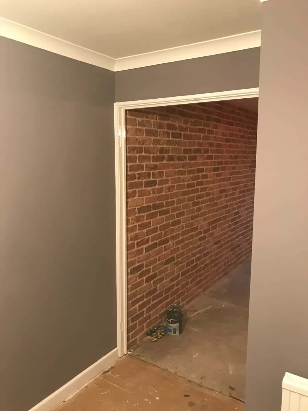 Newly plastered and painted room with an exposed brick alcove