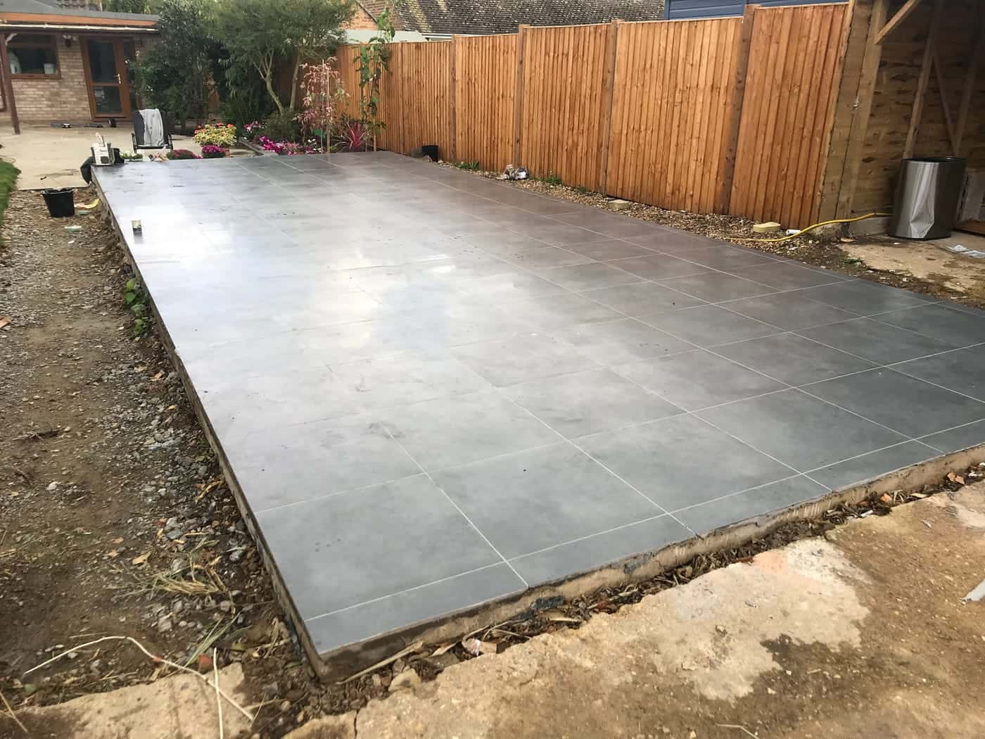 Large area of grey paving laid in a back garden